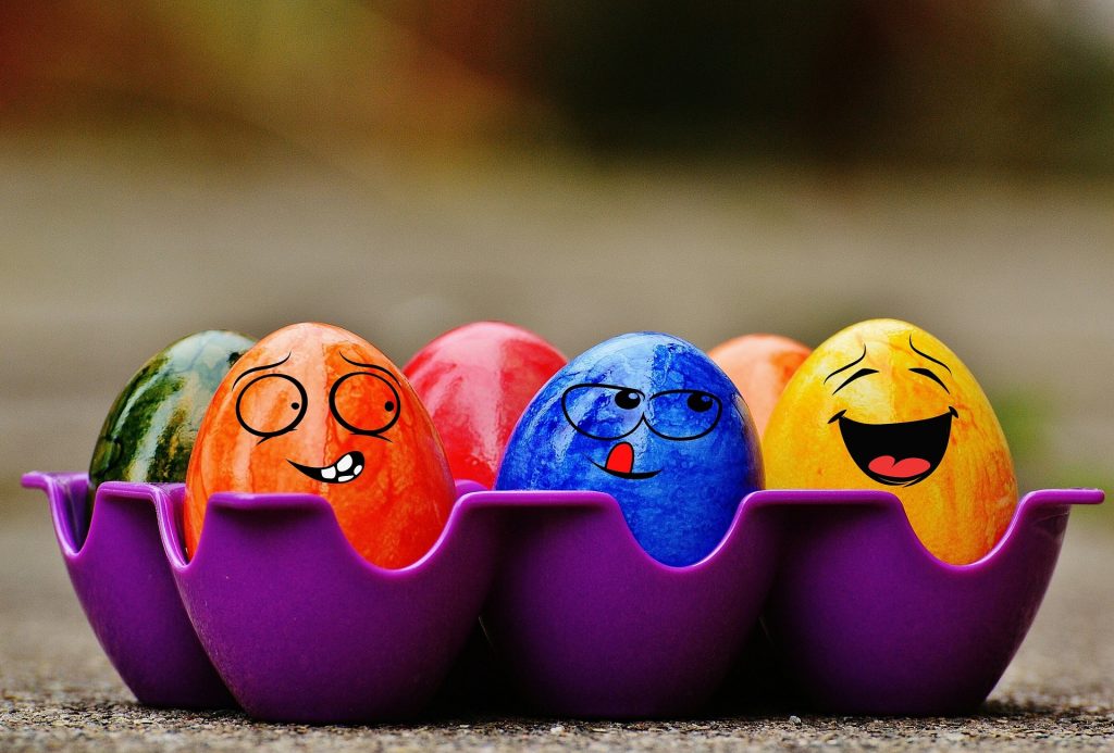 Half a dozen of colourful eggs with funny faces